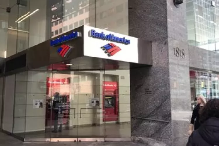 Street-level entrance to the Bank of America branch at 1818 Market, featuring a glass storefront, ATM access inside, and the building’s address etched into the stone facade. Pedestrians walk by in the bustling city setting.